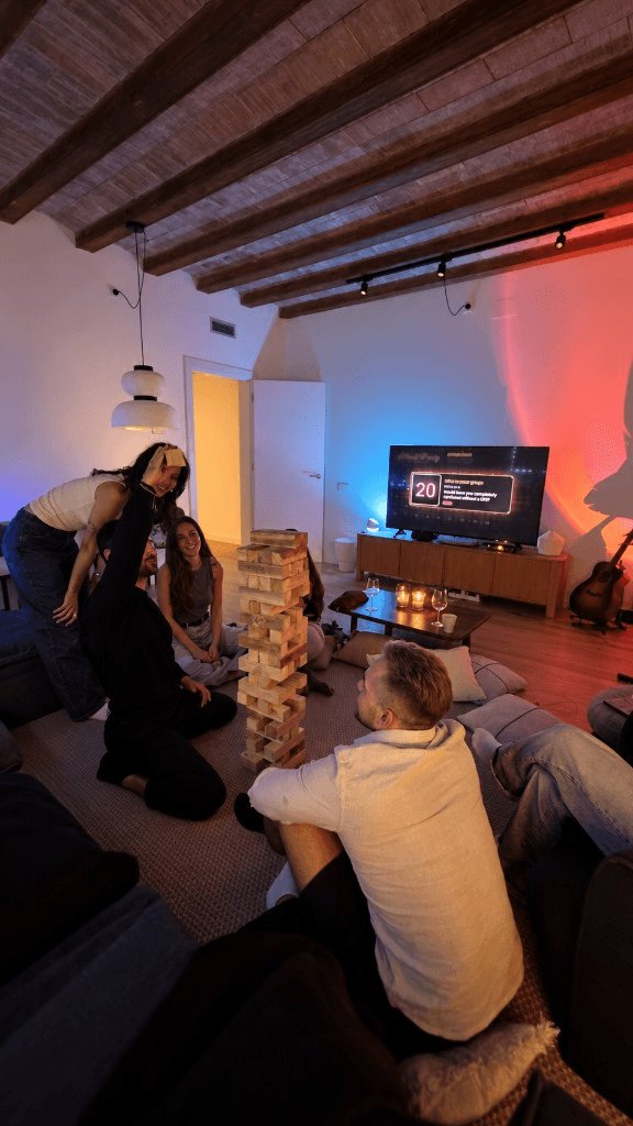 The living room with the tower on the floor, friends around it and card 20 up on the TV